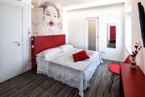 雷卡纳蒂CalaLaNotte的一间卧室配有一张大床和红色床头板
