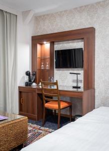 Bellevue库特奇餐厅酒店的酒店客房配有书桌、床和椅子。