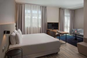 的里雅斯特NH特里斯特酒店的酒店客房设有一张大床和一张书桌。