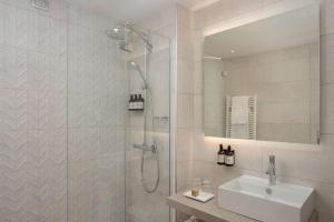 的里雅斯特NH特里斯特酒店的带淋浴和盥洗盆的浴室