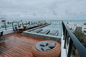 若昂佩索阿Flats na praia do Bessa的阳台设有游泳池、椅子和桌子。