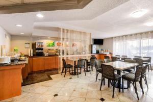 米西索加多伦多西部迪克西401品质套房酒店的一间带桌椅的餐厅和一间厨房