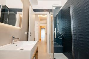 维耶斯泰Agorà Vieste Rooms & Apartments的一间带水槽和玻璃淋浴的浴室