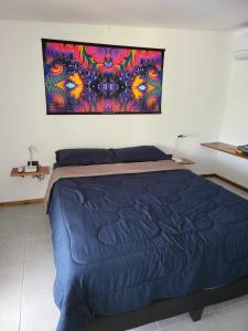 新孔Lost paradise 2的卧室配有一张蓝色的床,墙上挂着一幅画
