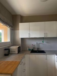 卡德德乌Cardedeu Circuit apartment的厨房配有白色橱柜、水槽和窗户。