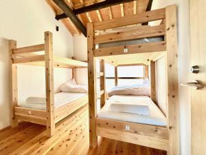 淡路kotobukian 寿庵的铺有木地板的客房内配有两张双层床。