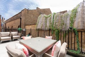 伦敦Grosvenor Mayfair的一个带桌椅和围栏的庭院
