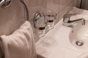 沃韦德拉广场酒店的浴室水槽配有2个玻璃杯和毛巾