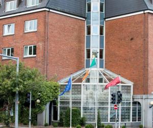科克Leonardo Hotel Cork的前面有旗帜的建筑