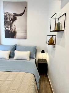 费拉古多Casa Pirilampo Ferragudo的卧室配有一张床,并画着公牛的照片