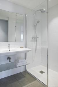戛纳艾博利亚酒店的白色的浴室设有水槽和淋浴。