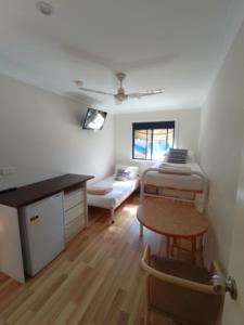 麦夸里港T's Resort & Motel的配有床、桌子和沙发的房间