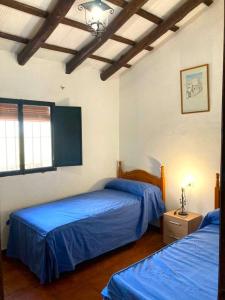 查兹拉德拉谢拉Finca Villa Coral的配有蓝色床单的客房内的两张床