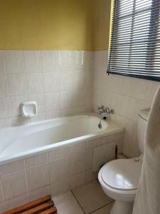 贝拉贝拉Pendleberry Holiday Resort - Unit 41的浴室配有白色浴缸和卫生间。