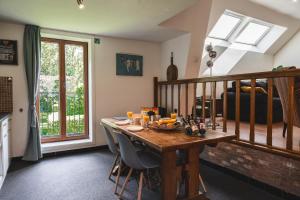 比尔曾Vakantiewoning & Fietslogies V E L O, Tussen Hasselt en Maastricht的用餐室配有木桌和椅子