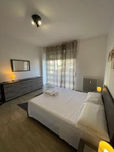 诺瓦拉Accogliente Loft ben servito的卧室设有一张白色大床和一扇窗户。