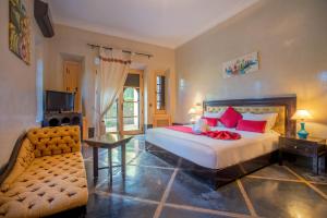 马拉喀什Janat Al Atlas Resort & Spa的一间卧室配有一张床、一张沙发和一台电视