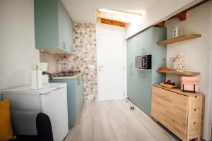 圣克鲁斯-德特内里费Casa Tulipanes & Spa的一间小厨房,配有蓝色橱柜和一台洗衣机