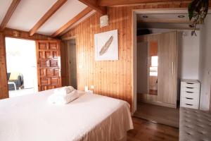 圣克鲁斯-德特内里费Casa Tulipanes & Spa的卧室设有白色的床和木墙