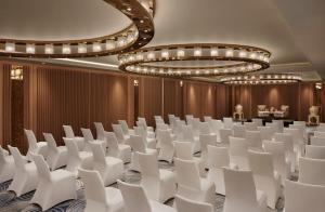 斋浦尔Taj Amer, Jaipur的一间会议室,配有白色椅子和吊灯
