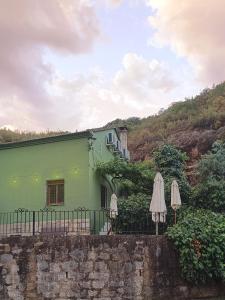 丘利利亚Refugio La Presa的前面有两把遮阳伞的绿色房子