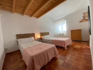 埃斯波尔莱斯Finca es Born - vistas panorámicas的一间卧室设有两张床和木制天花板