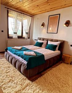 莱什顿Rooms in Leshten的卧室内的一张大床,配有一张大床和一张大号的四柱床