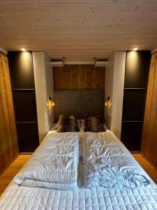 耶卢Fin leilighet på Geilotunet leies ut的卧室设有一张白色大床,拥有木墙
