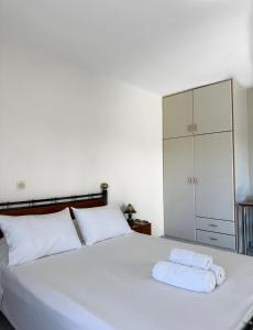 里科索翁帕戈尼斯公寓酒店的卧室配有白色的床和2条毛巾