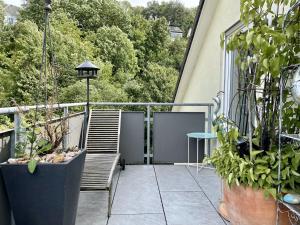 斯图加特Guest Room in Stuttgart-Nord的阳台配有两把椅子和一张桌子,还有一些植物
