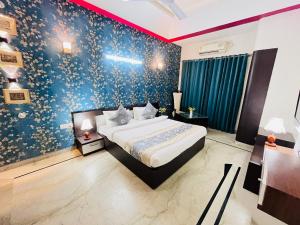 古尔冈Hotel Dayal Regency near IMT Chowk Manesar, Manesar的一间卧室设有一张床和蓝色的墙壁
