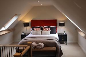 埃文河畔斯特拉特福Piglet's Hideaway的一间卧室配有一张大床和红色床头板