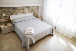 马里纳迪马萨Residence Deamarina的一间卧室配有一张床,上面有两条毛巾