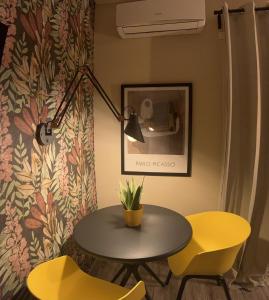 菲乌米奇诺Kalasó Design Guest House的一张桌子和两张黄色椅子