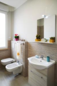 马里纳迪马萨Residence Deamarina的一间带水槽、卫生间和镜子的浴室