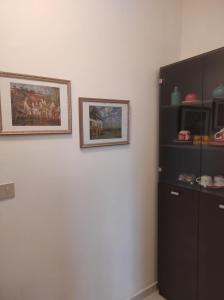 兰恰诺Buongiorno Majella - Appartamento con piscina的墙上有两张照片的房间和橱柜