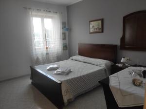 兰恰诺Buongiorno Majella - Appartamento con piscina的一间卧室设有一张床和一个窗口