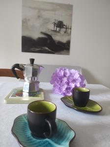 兰恰诺Buongiorno Majella - Appartamento con piscina的桌子上放着两个咖啡杯和鲜花