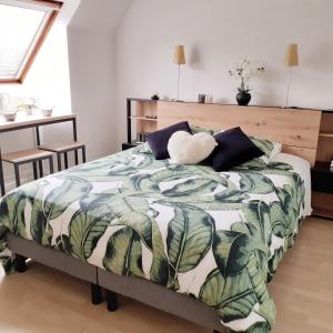 圣提里耶拉佩尔什Maison de la Loue"的一间卧室配有一张带绿色和白色毯子的床