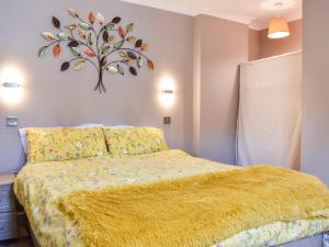 BurnopfieldRoxys Cottage - Uk44687的一间卧室配有一张黄色毯子床