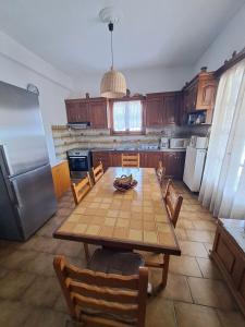 MárpissaCycladic House in Paros的厨房配有桌椅和冰箱。