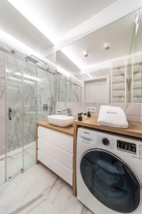 比亚韦斯托克ResiNest Apartamenty Jagiellońskie J11的带淋浴的浴室内的洗衣机