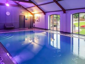 Gilcrux贝克塞德乡村别墅的紫色照明的房子里的一个游泳池