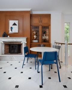 雅典The Southern Mansion Athens的一间带桌椅和壁炉的用餐室
