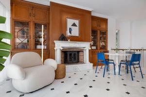 雅典The Southern Mansion Athens的客厅设有壁炉、桌子和椅子