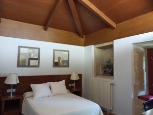 VillamarínCasa das Capelas的一间卧室设有一张床和木制天花板