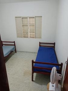 帕苏斯Chacara Tropicalia的客房设有两张床和风扇。