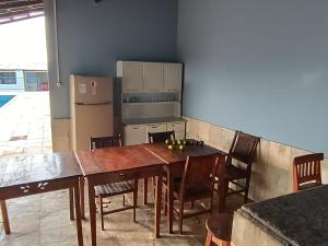 帕苏斯Chacara Tropicalia的厨房配有桌椅和冰箱。