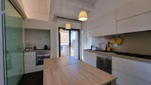 里米尼ATTICO Rimini Centro - Palacongressi的厨房配有白色橱柜和木制台面