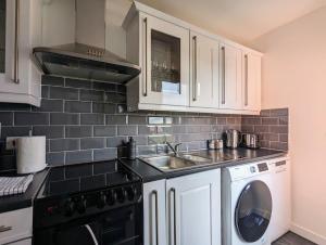 海维康Conegra Road by Wycombe Apartments的厨房配有白色橱柜、水槽和洗碗机。